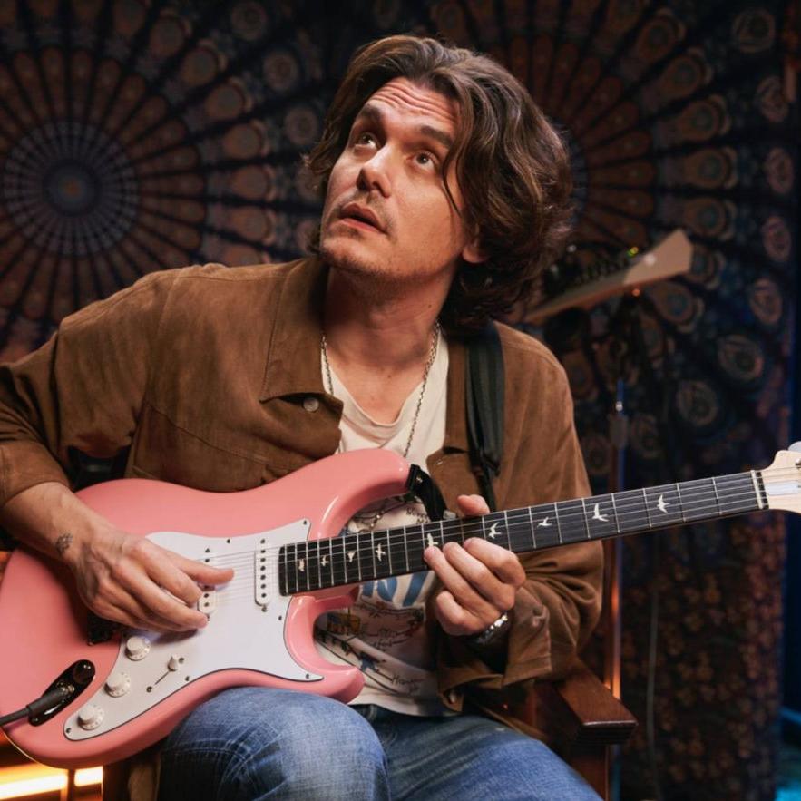 John sitting in studio with pink PRS guitar.