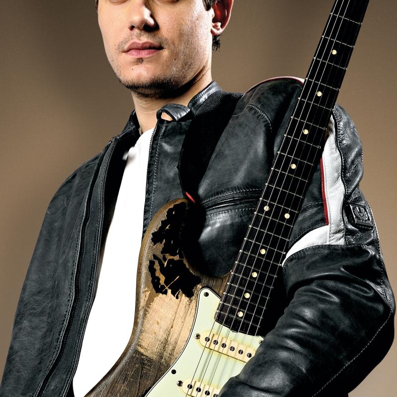 John Mayer posing with a Fender Stratocaster electric guitar.